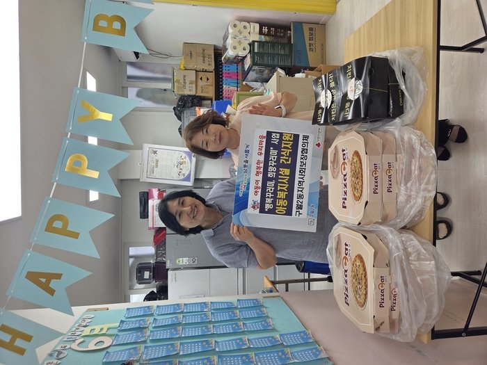 Representatives from the Guwol 2-dong Community Social Security Council visit a child welfare facility to deliver snacks including chicken and pizza.