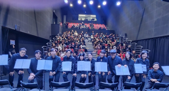 공연 관계자들이 객석을 가득 메운 관객들과 함께 자리하고 있다.