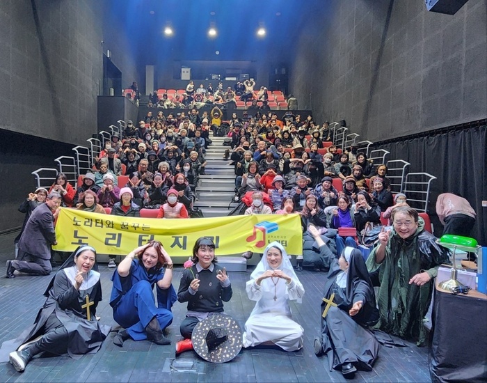 금천시민극단 노리터 공연 무대인사에서 배우와 관객들이 '노리터와 꿈꾸는 노리터지기' 현수막 앞에서 기념촬영을 하고 있다.