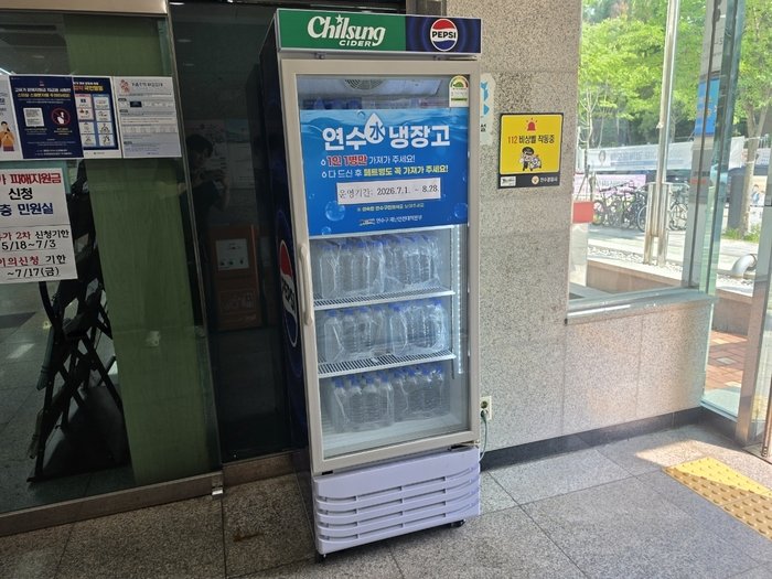 행정복지센터에 배치된 연수(水) 냉장고에서 생수를 꺼내는 구민