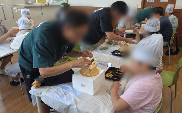 인천장애인종합복지관이 지난 11일 복지관에서 마련한 '아빠 모임'에 참여한 가족들이 과자집을 만들고 있다.